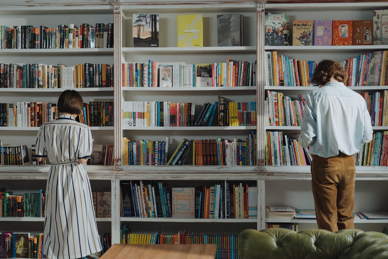 Two people browsing books in a cozy library, searching for their next great read.